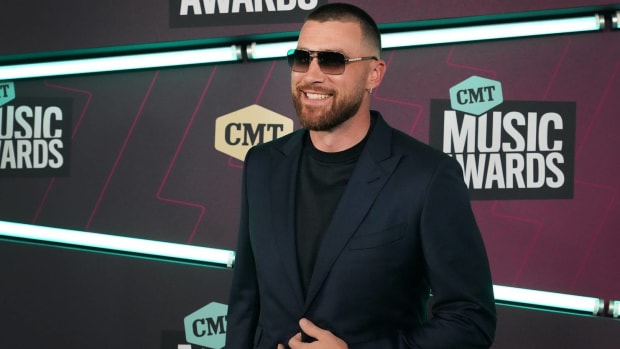 Chiefs tight end Travis Kelce smiles on the red carpet at the CMT Music Awards.